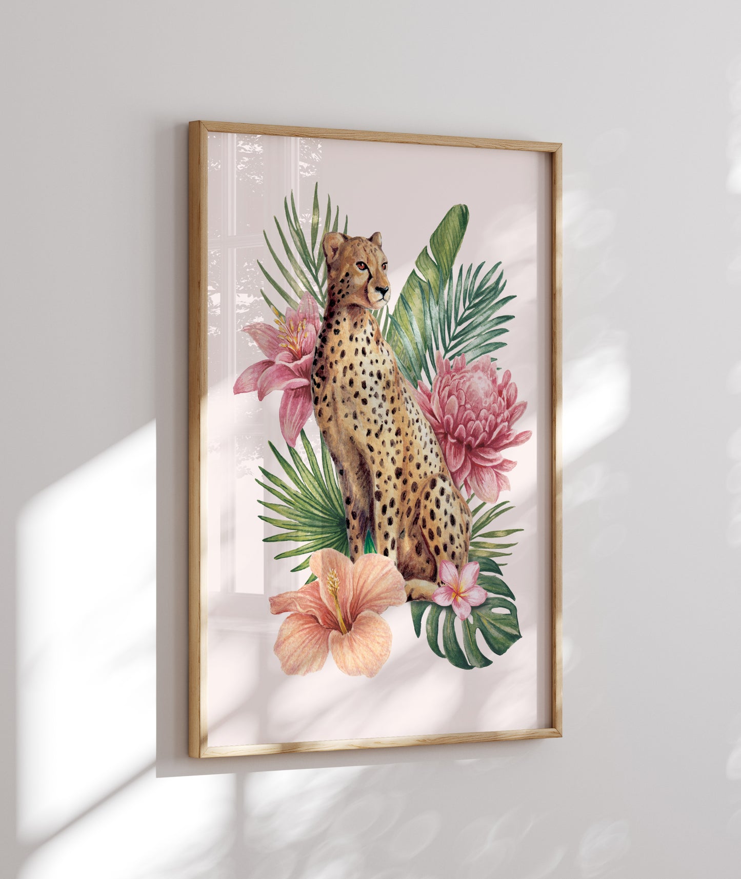 Framed artwork of a cheetah among tropical leaves and flowers on a white wall.