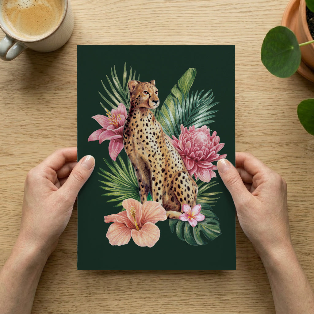 Person holding a print with a cheetah and floral design on a wooden table.