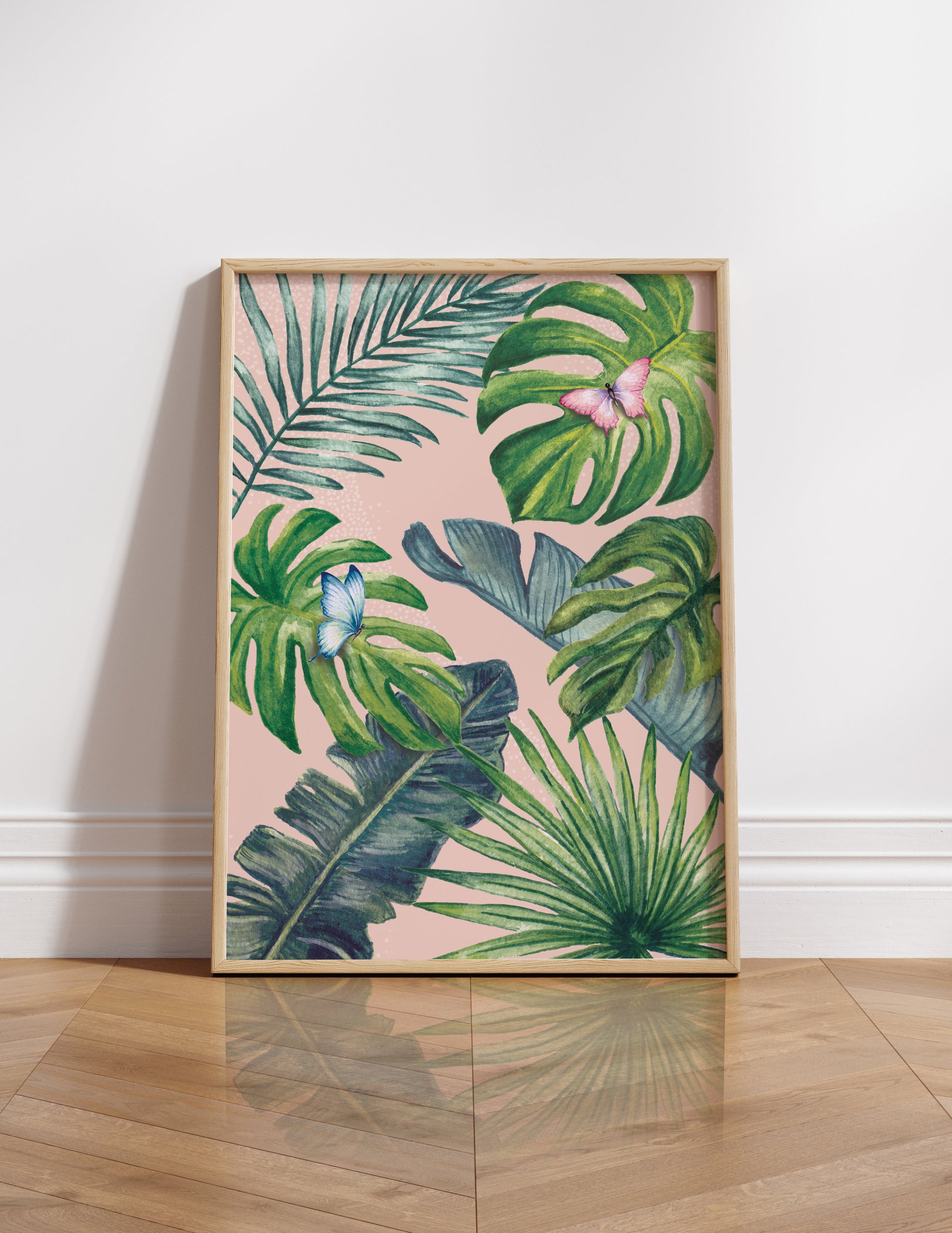 Framed artwork with tropical leaf design on a white wall.