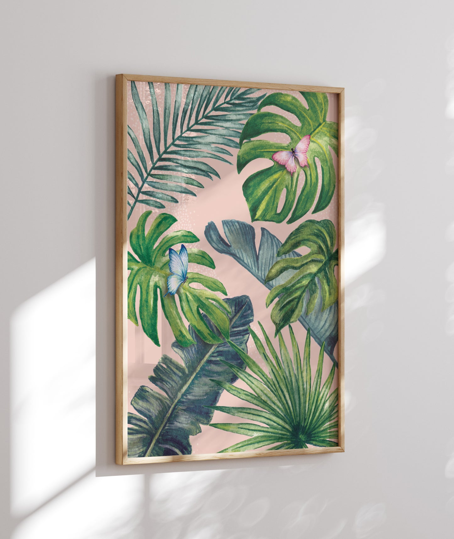 Framed artwork with tropical leaf design on a pink background