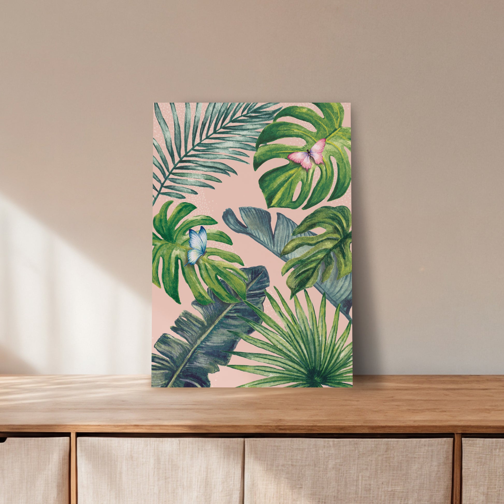 Art print with tropical leaf design on a wooden surface and beige wall background