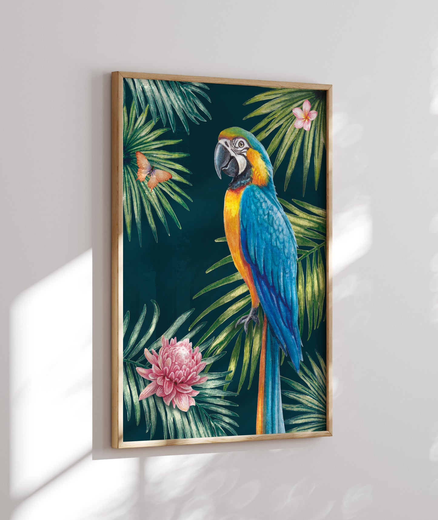 Framed artwork of a parrot and tropical leaves on a white wall