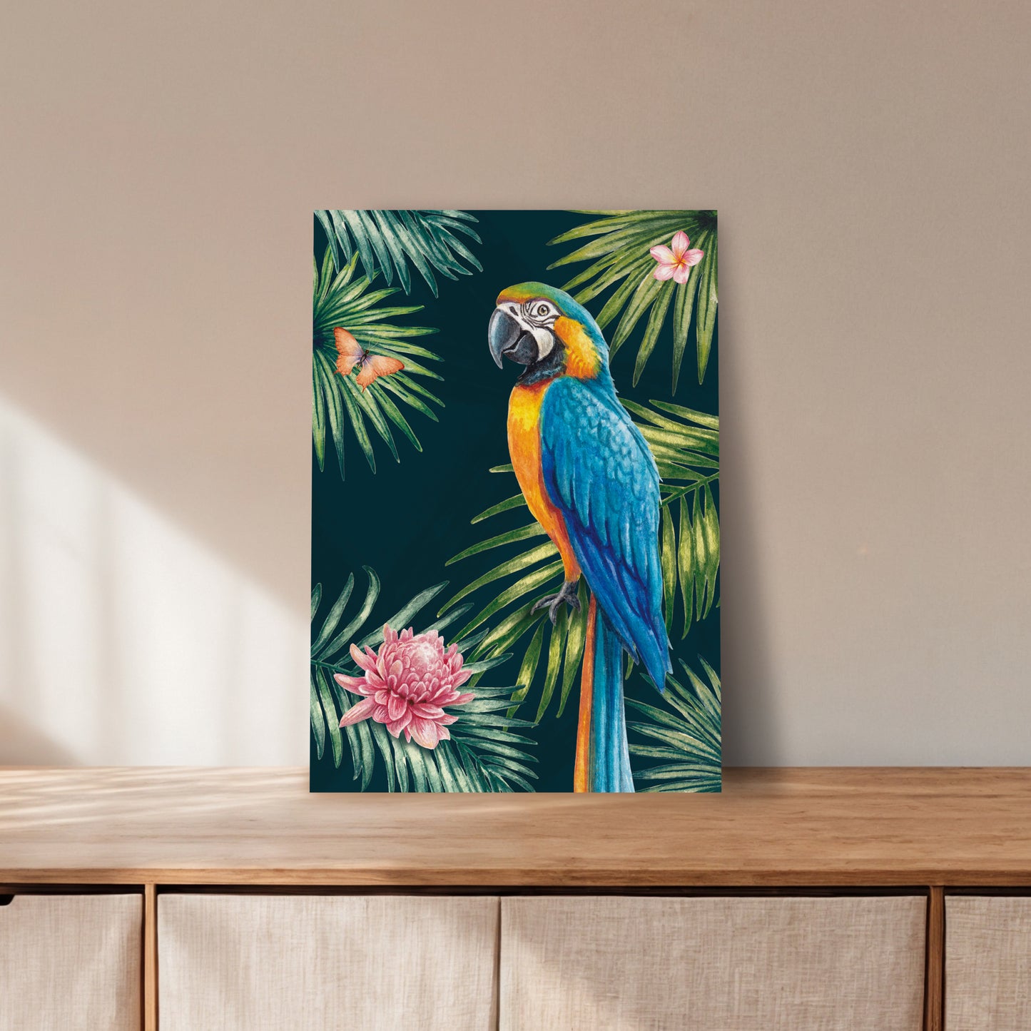 Canvas print of a colourful parrot and tropical leaves on a wooden surface with a beige wall background.