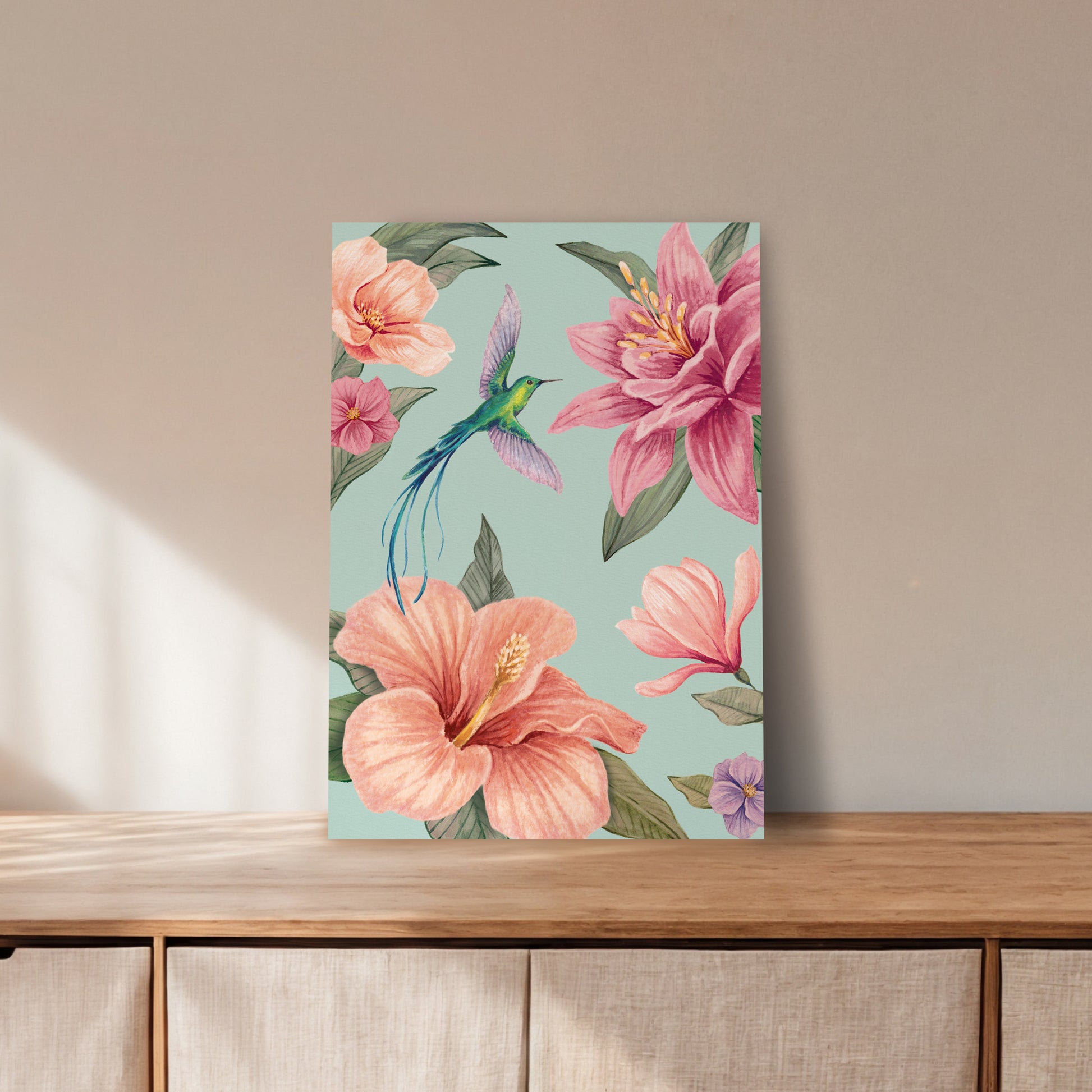 Art print with a colourful floral design featuring pink flowers and a hummingbird on a wooden surface.